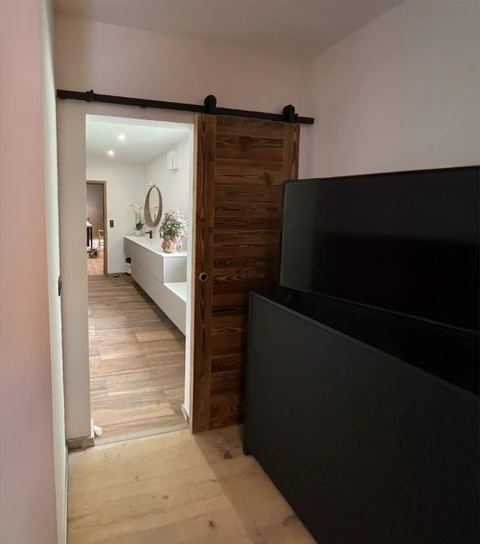 Intérieur résidentiel moderne avec porte coulissante en bois sur rail apparent noir