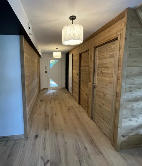 Couloir intérieur moderne avec parquet en bois naturel, murs lambrisés en planches de chêne massif