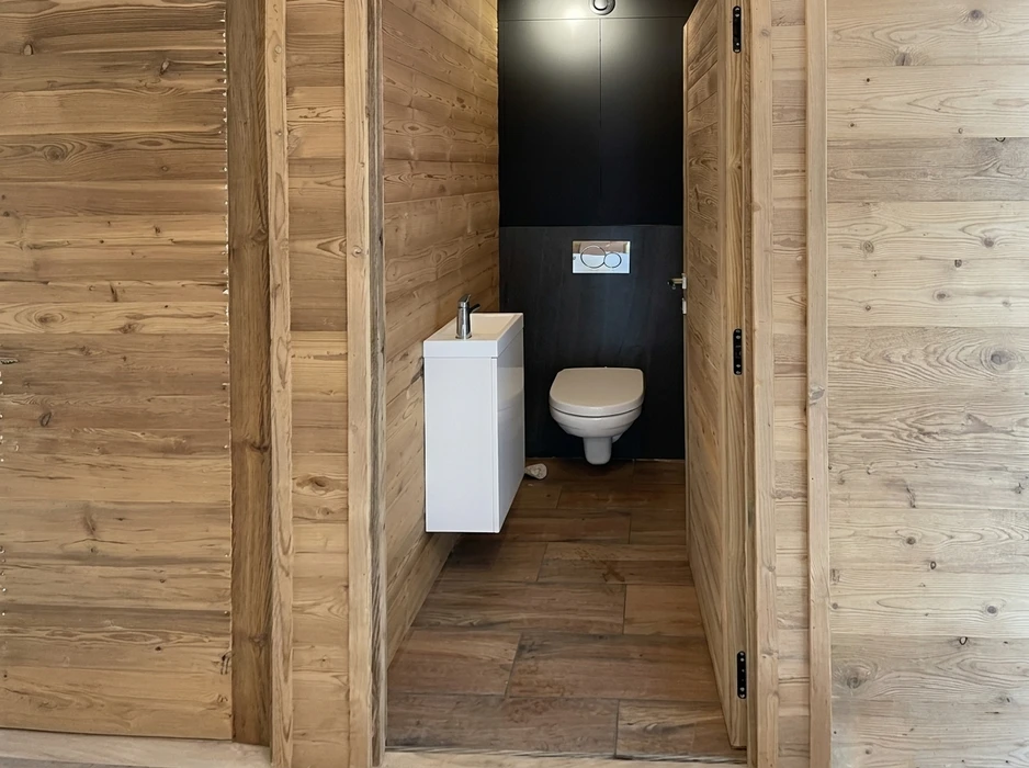 Espace de vie extérieur couvert avec piscine intégrée, table de repas en bois et chaises pliantes
