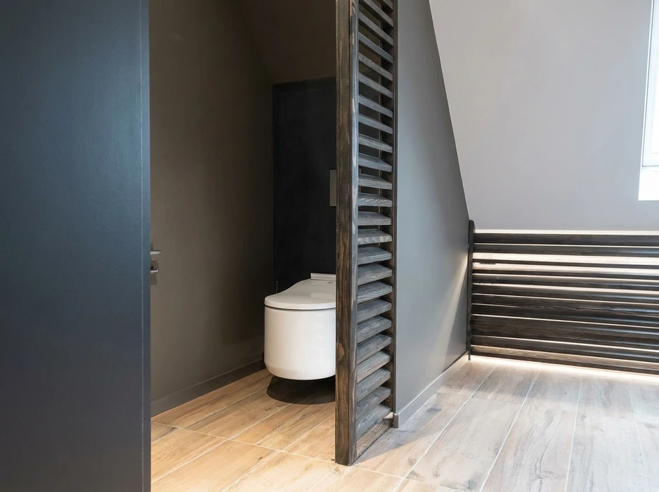 Toilettes modernes dans espace résidentiel avec murs en lambris bois naturel