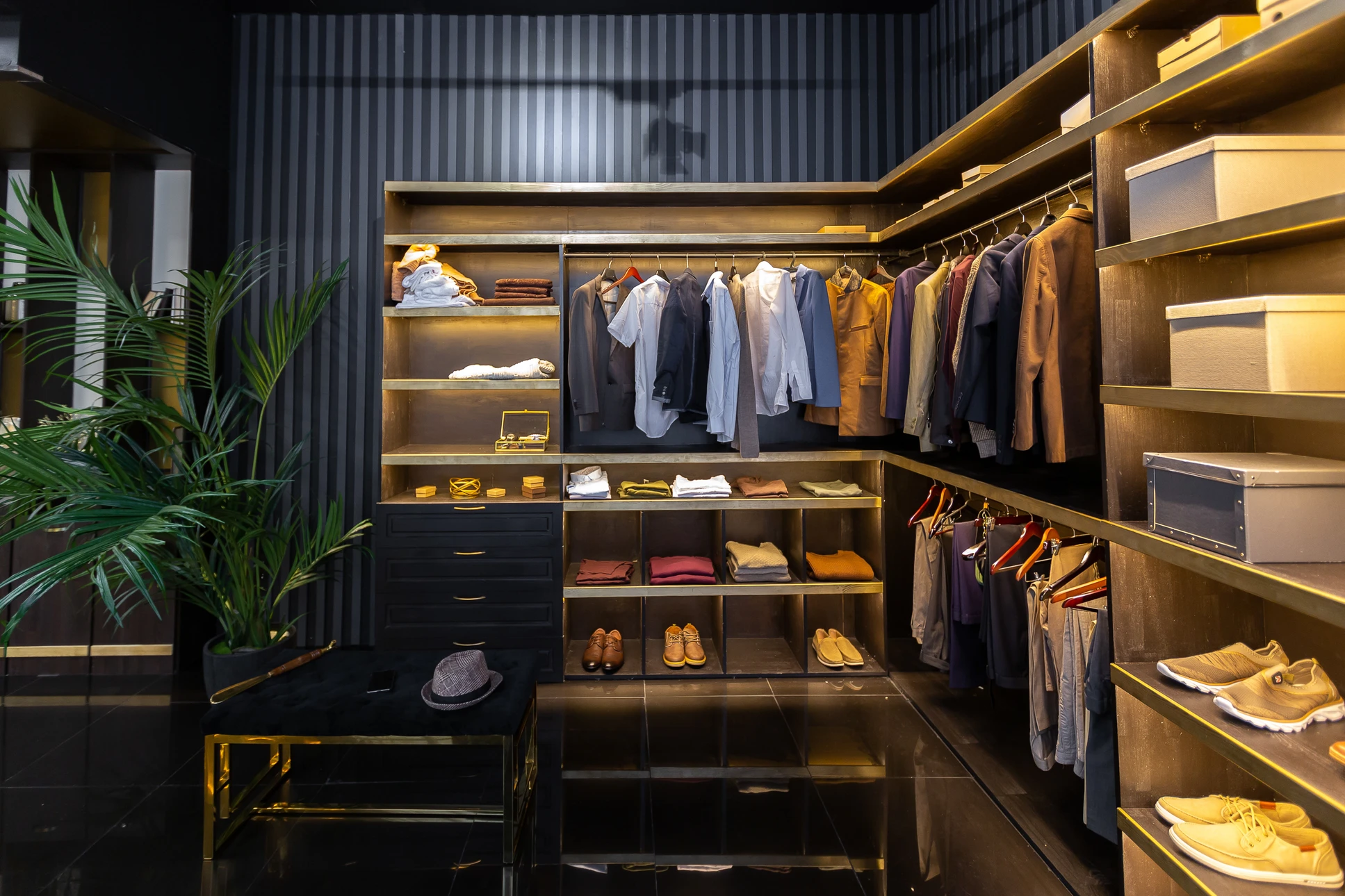Dressing moderne avec aménagement sur mesure en bois clair, comprenant penderies avec éclairage LED intégré, étagères de rangement, tiroirs et compartiments pour chaussures